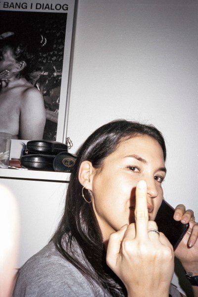A woman holds her middle finger up.