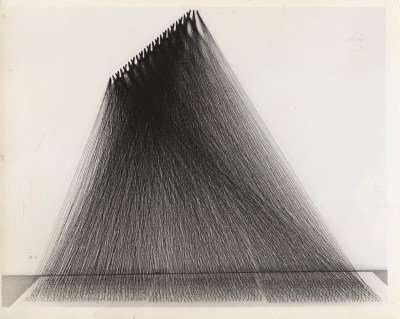 A sculpture composed of black strings tied to a wall.